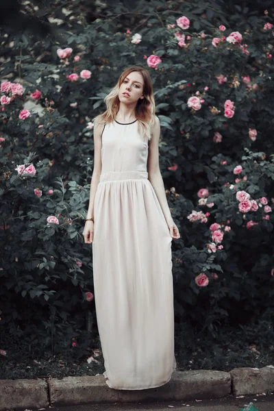 Hermosa joven en vestido rosa de moda que huele a rosas. Cuento de hadas. Moda. Fantasía —  Fotos de Stock