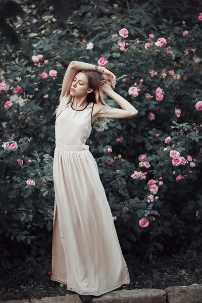 Hermosa joven en vestido rosa de moda que huele a rosas. Cuento de hadas. Moda. Fantasía — Foto de Stock