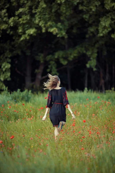 Belle fille ukrainienne s'amuser dans le champ de pavot . — Photo