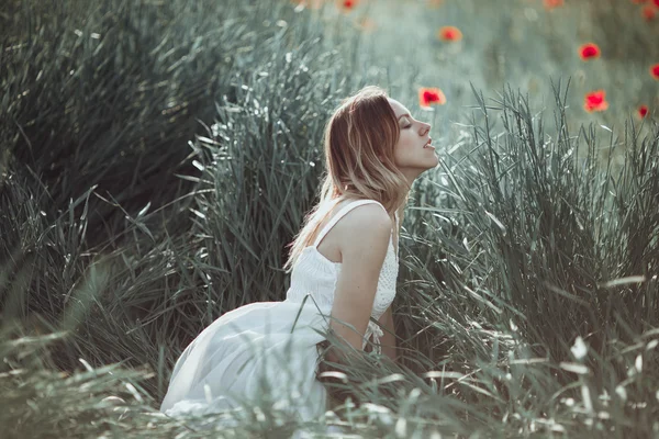 Красиві Українська дівчина з задоволенням в макового поля. — стокове фото