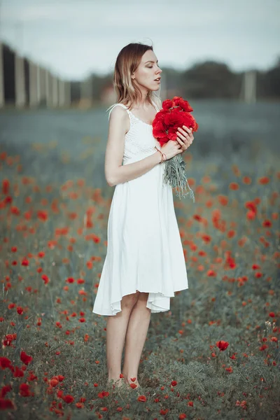 Menina ucraniana bonita se divertindo no campo de papoula . — Fotografia de Stock