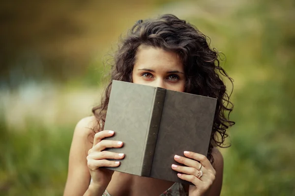 Belle jeune fille étudiant sur l'herbe verte. Lecture de livres — Photo