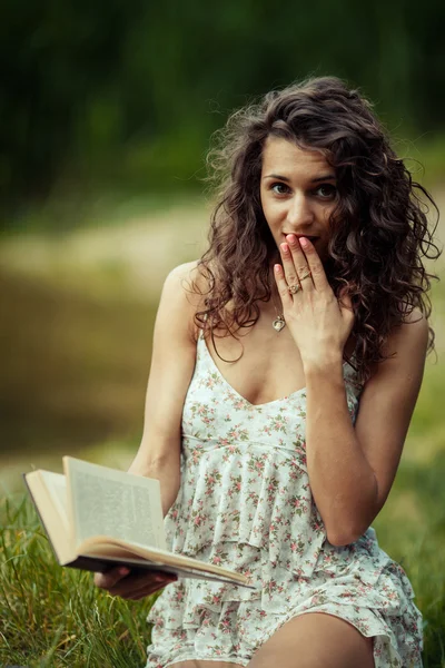 Belle jeune fille étudiant sur l'herbe verte. Lecture de livres — Photo