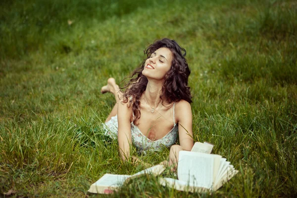 Belle jeune fille étudiant sur l'herbe verte. Lecture de livres — Photo