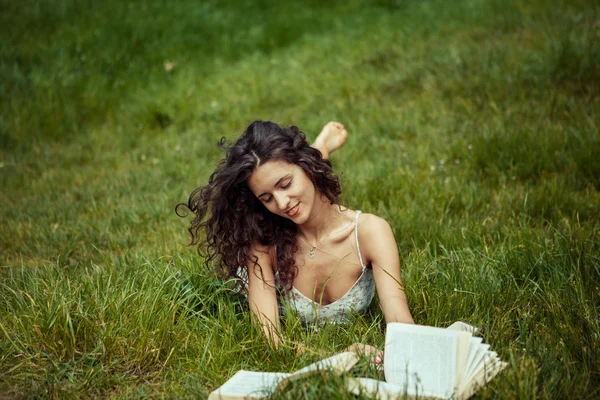 Όμορφη νεαρή κοπέλα που σπουδάζει στο πράσινο χορτάρι. Ανάγνωση βιβλίων — Φωτογραφία Αρχείου