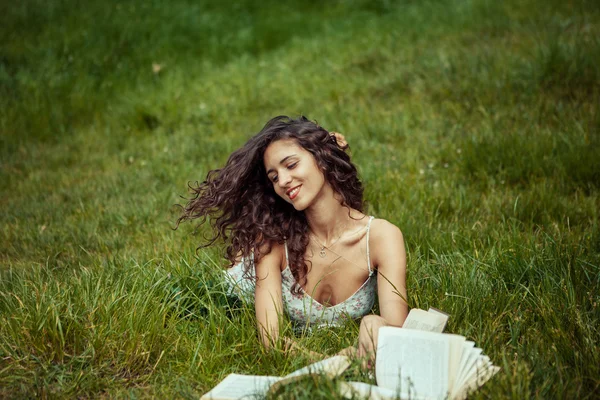 Beautiful young girl studying on green grass. Reading books — Stock Photo, Image