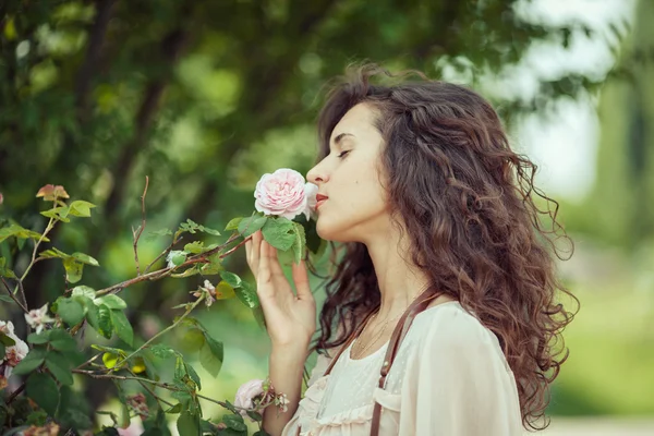 Belle fille sent rose rose dans le jardin de printemps — Photo