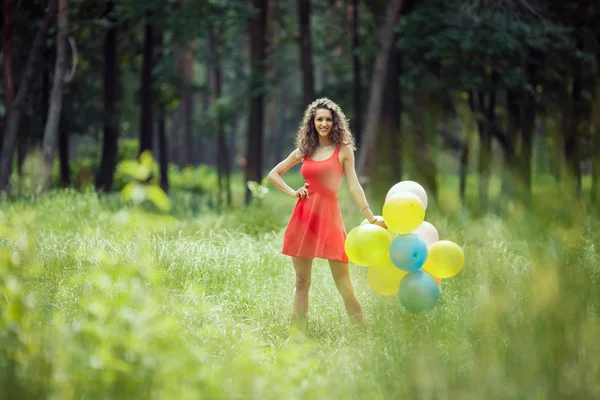 Belle jeune fille qui s'amuse au parc d'été avec des ballons colorés. Joyeux sourire concept de saut — Photo