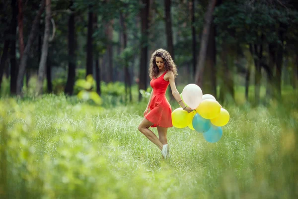 Hermosa joven divirtiéndose en el parque de verano con globos de colores. concepto de salto sonrisa feliz —  Fotos de Stock