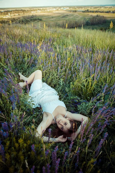 Hermosa chica en el campo de flores de salvia . — Foto de Stock