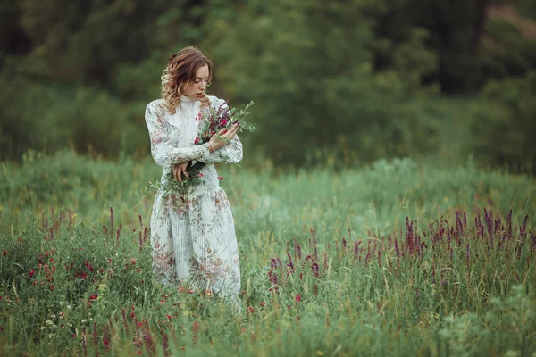 Fiatal lány vintage ruha zsálya virág mező, séta. — Stock Fotó