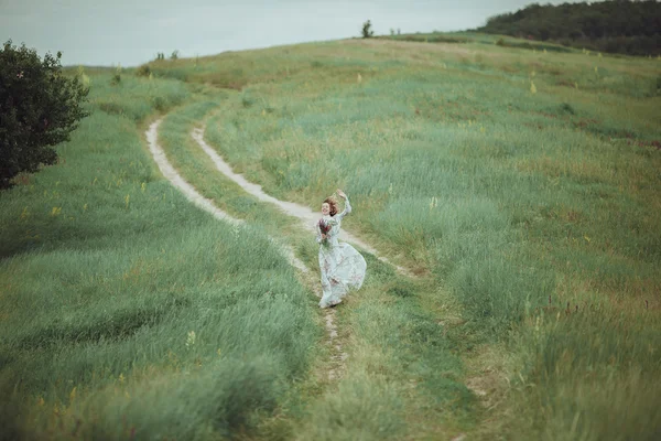 Chica joven en vestido vintage caminando por el campo de flores de salvia . —  Fotos de Stock