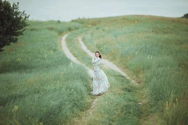 Chica joven en vestido vintage caminando por el campo de flores de salvia . —  Fotos de Stock