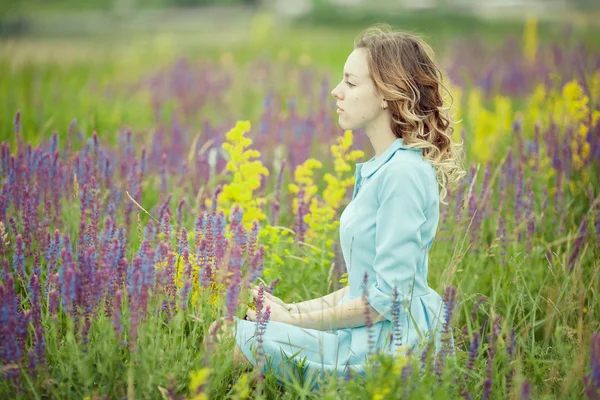 Giovane ragazza in abito vintage a piedi attraverso il campo di fiori salvia . — Foto Stock