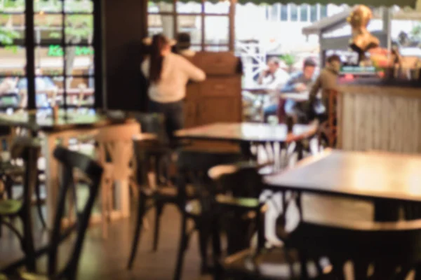 Ljus defocused suddig bakgrund med oigenkännliga människor i ett café. Abstrakt bild av folkmassan på offentlig plats. — Stockfoto