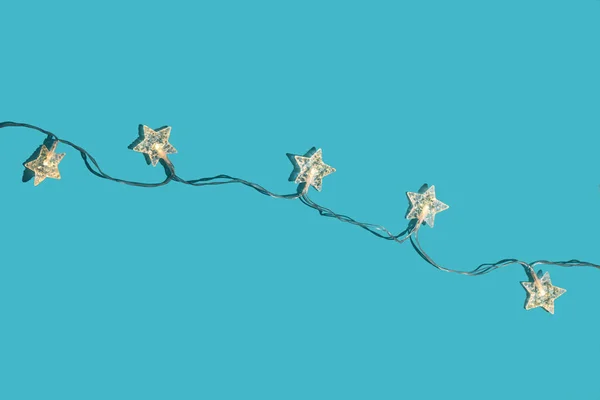 Weihnachten minimaler festlicher Hintergrund mit Sternengirlanden. Abstrakte Weihnachten Hintergrund glänzend blau ai aqua. Flach lag er. Ansicht von oben. — Stockfoto