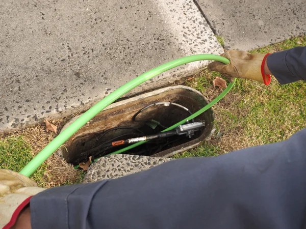 Instalador que tira del cable de fibra óptica en el conducto — Foto de Stock