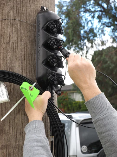 Kunden lokaler droppe anslutningskabel är inkopplad i ett multiport på en stolpe, en del av Australian National Broadband Network — Stockfoto