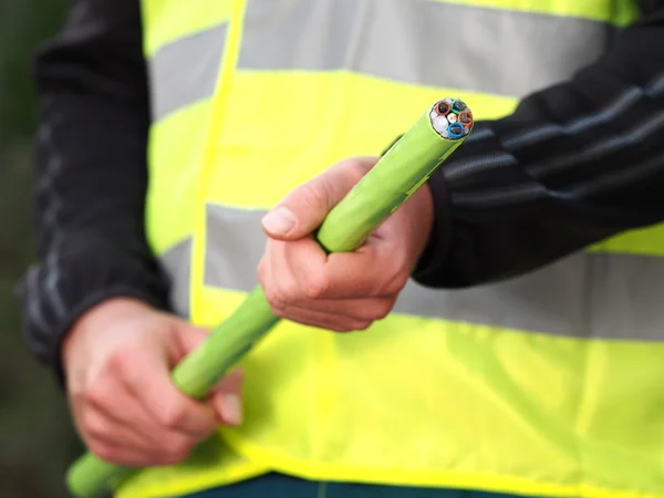 Installer håller en grön Nylon hölje 576 fiber optic bandkabel — Stockfoto