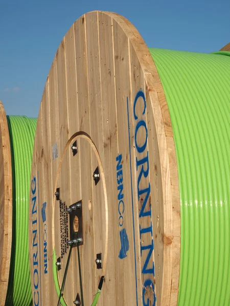 Large 2 meter timber drums with green 576 fiber fiber optic cable in a transport hub for freight, used in the Australian National Broadband Network fiber to the Home Roll-out