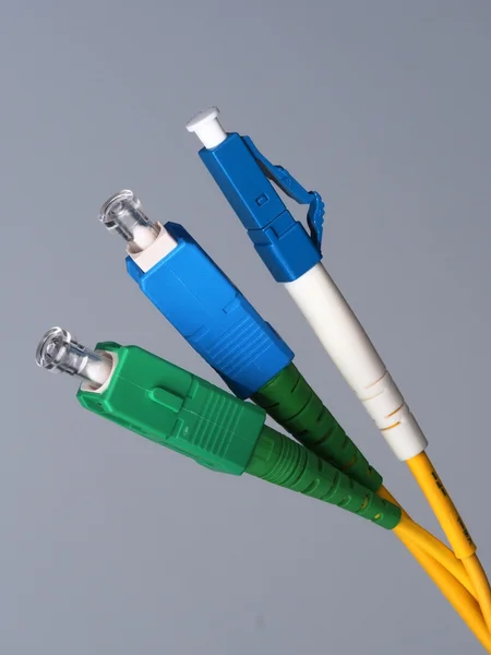 Three single fiber optic connectors used for indoor fiber optic network installation — Stock Photo, Image