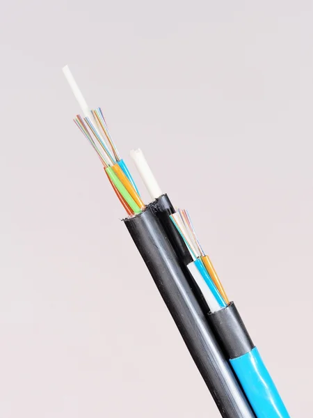 Blue fiber optic cable in front of a black Figure 8 aerial cable with stripped and exposed — Stock Photo, Image