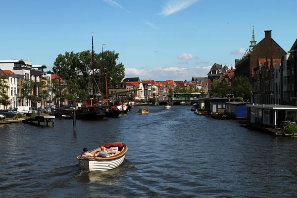 Small boat on canal between historic building cruising towards Leiden — 图库照片