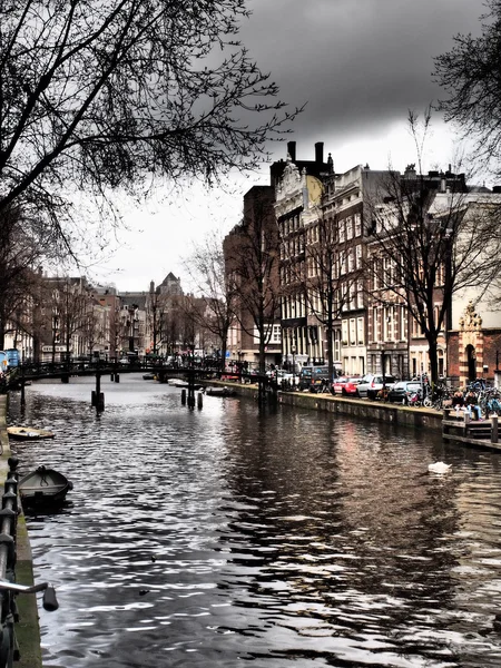 Canal with bridge and residential housing with dramatic clouds on a gloomy day — 图库照片