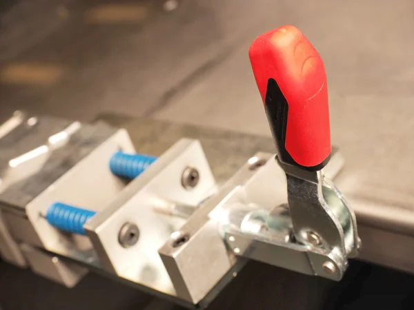 Alavanca de plástico vermelha de um dispositivo de aperto mecânico industrial — Fotografia de Stock