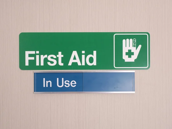 First aid door sign with occupied indicator — Stock Photo, Image