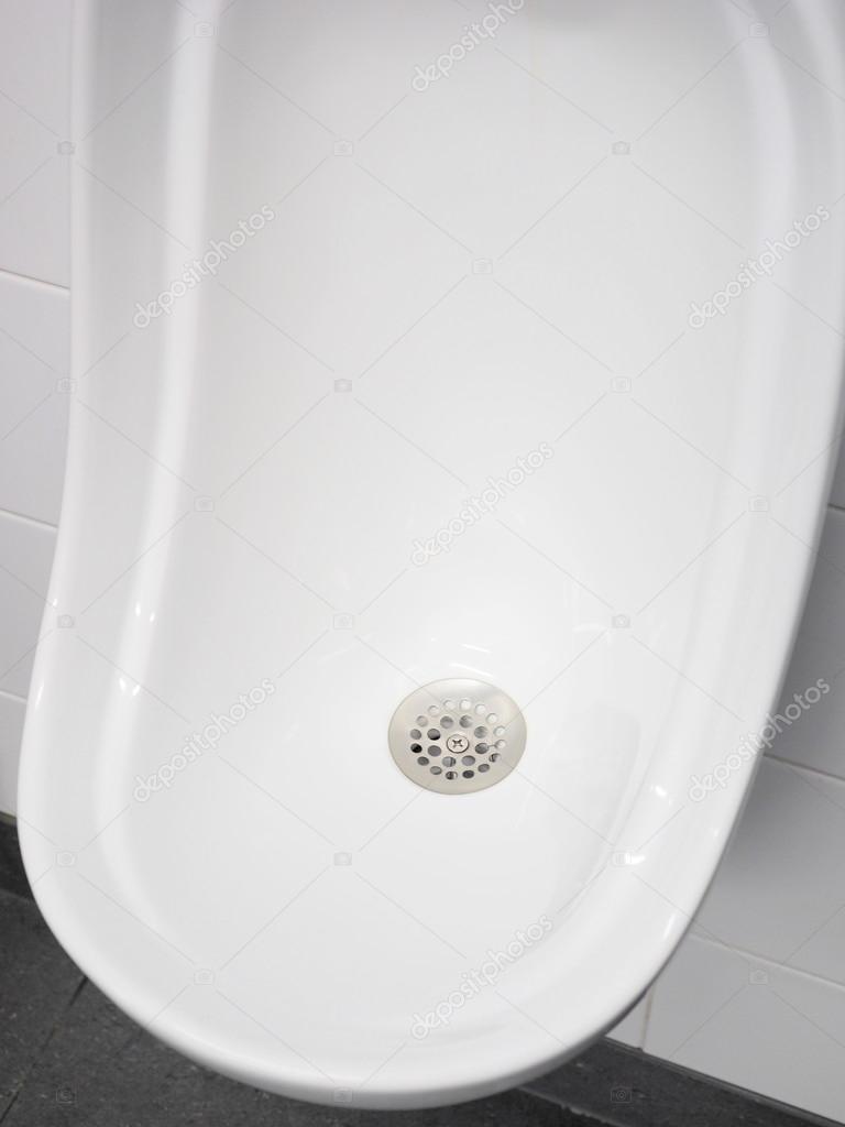 Urinal bowl with stainless strainer in a pristine lavatory