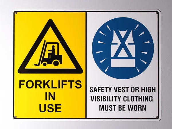Предупреждение грузовика вилочного погрузчика и знаки на стене жилета высокой видимости — стоковое фото