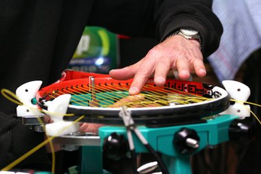 Raket stringer sentetik gut dizenin çapraz dizeleri bir tenis raketi dokuma