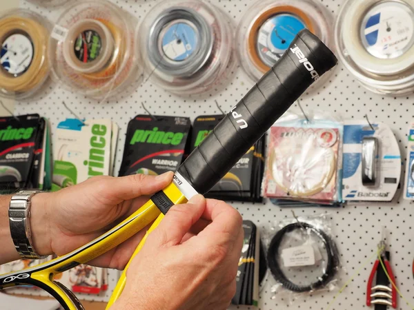 Wrapping of the finishing tape on a freshly wrapped Tennis racquet base grip — Stock Photo, Image