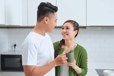 Romantik genç çift mutfakta birlikte yemek pişiriyor, birlikte harika vakit geçiriyorlar..