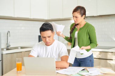 Kızgın genç çift evdeki borçları yüzünden kavgalı bir şekilde bağırıyor. Finansal aile sorunları kavramı.