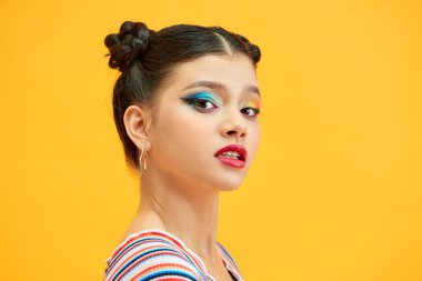 Çekici gülümseyen genç bir kadının güzel portresi. Sarı arka planda tek başına duran, poz veren.