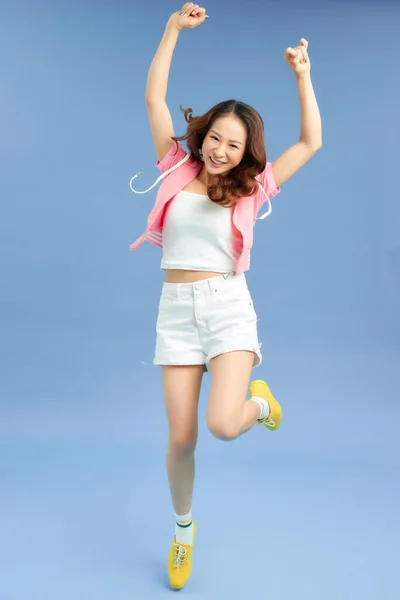 Happiness, freedom, movement and people concept - smiling young woman jumping in air.