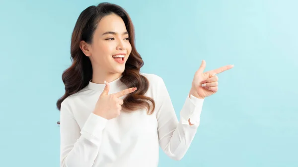 Smiling Woman Pointing Finger Side Isolated Portrait Blue — Stock Photo, Image