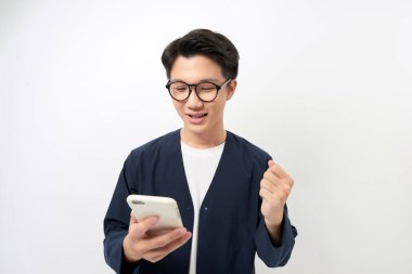 Şaşırmış genç adam telefon tutuyor ve beyaz arka planda izole edilmiş mesajlar okuyor..