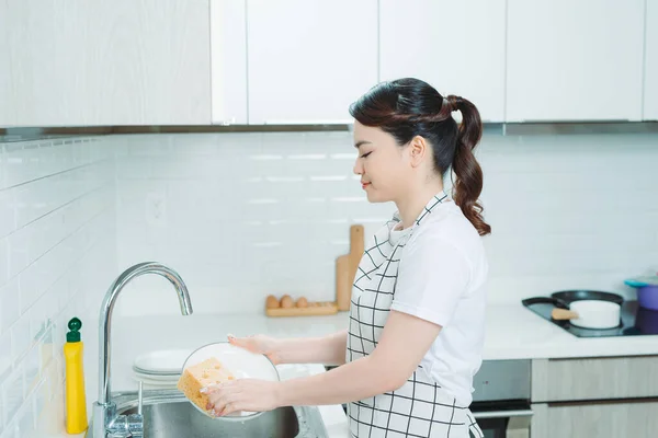 Een Aantrekkelijke Jonge Vrouw Afwassen Terwijl Thuis Schoonmaakt — Stockfoto