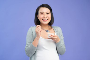 Yoğurt yiyen hamile kadın portresi