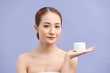 Cilt bakımı. Kozmetik losyon kavanozu tutan genç bir kadın..