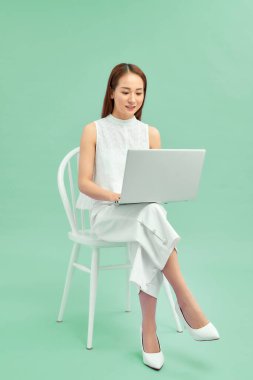 Dizüstü bilgisayarla çalışan güzel ve mutlu bir kadın.