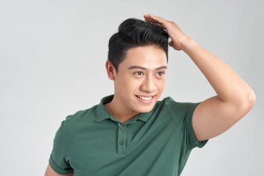 Yüz ifadesi. Saçını düzeltirken gülümseyen yakışıklı bir adamın portresi.