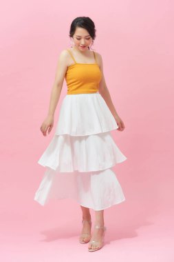 Uzun beyaz etekli muhteşem kadın samimi bir gülümsemeyle dans ediyor..