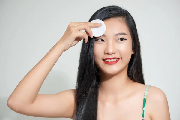 Skin care woman removing face makeup with cotton pad, skin care concept.