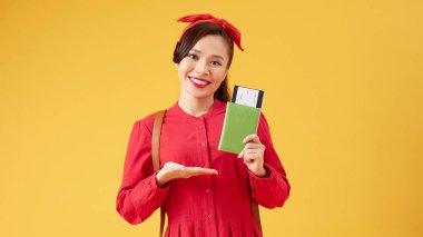 Yolculuk zamanı. Günümüz modasına uygun gülen kadın uçak biletleri ve elinde pasaportuyla..