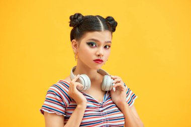 Kırmızı gömlekli güzel bir bayan. Kulaklığı boynunda. Elini boynundan ayırmıyor.