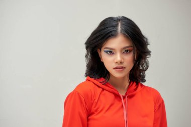 Güzel moda portresi. Gri arka planda gülümseyen genç kadın.